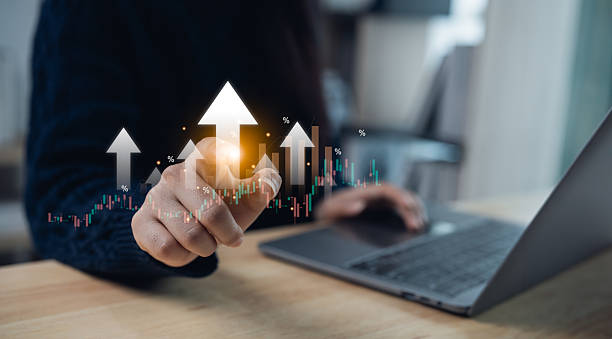 istock Professional Person Using Laptop and Interactive Graphs with Upward Arrows to Represent Growth and Success in a Modern Office Environment 2219249821