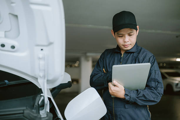 istock Mechanic performing maintenance on a vehicle in a parking garage setting during daylight hours 2219251562