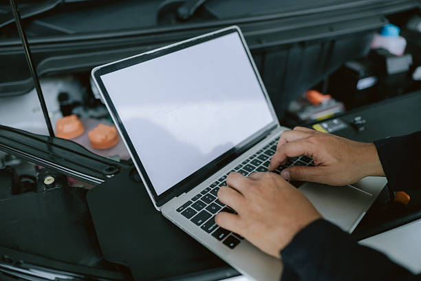 istock Mechanic performs diagnostics using laptop on car engine during maintenance at an automotive workshop 2219252068