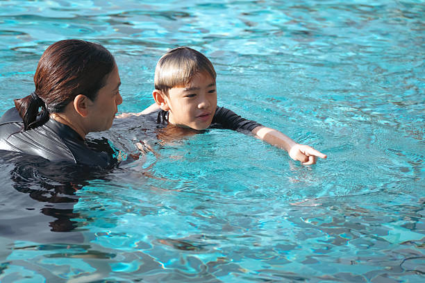istock Woman teaching boy to swim in pool 2219253082