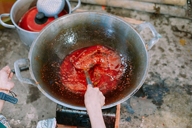istock Stirring vibrant red sauce in oversized wok outdoors kitchen scene 2219254803