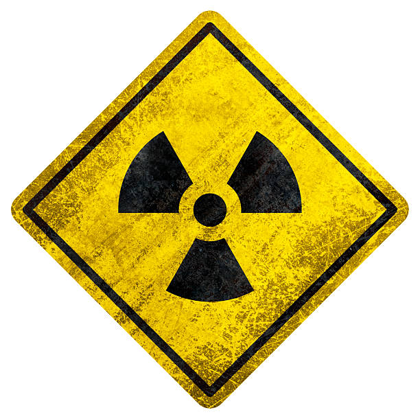 Yellow warning sign with radiation symbol and aged texture on white background.