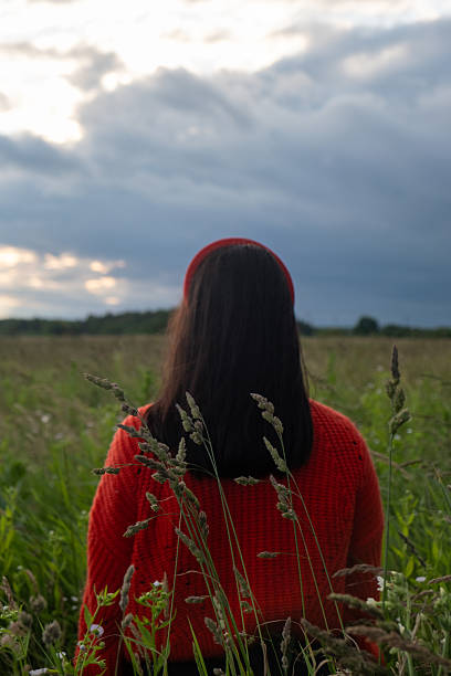 istock Woman in Red Sweater in Grassy Field 2219260629