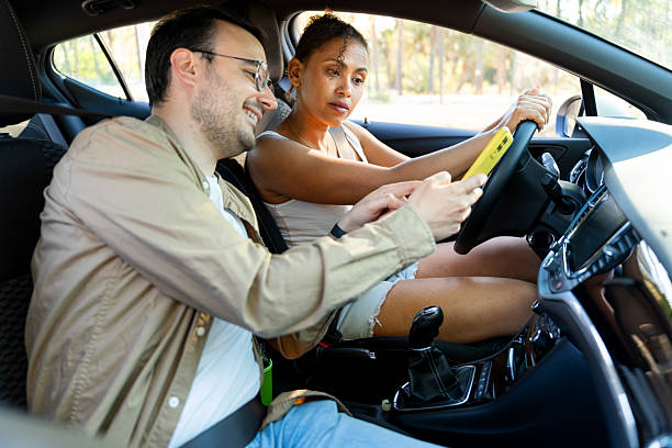 istock Couple driving car using gps navigation on mobile phone 2219260935