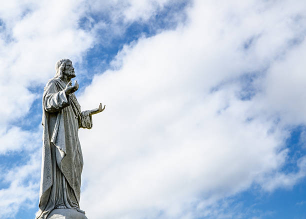 Jesus Christ statue standing against the cloudy sky, traditional branches of Christianity such as Catholicism, Orthodoxy, or Anglicanism