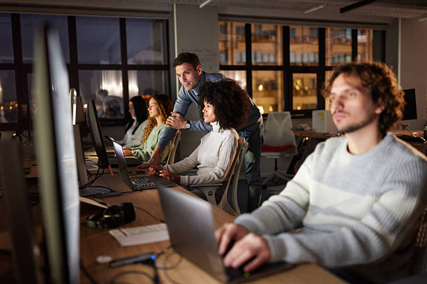 istock Diverse graphic designers working on desktop PC late in the office. 2219262827