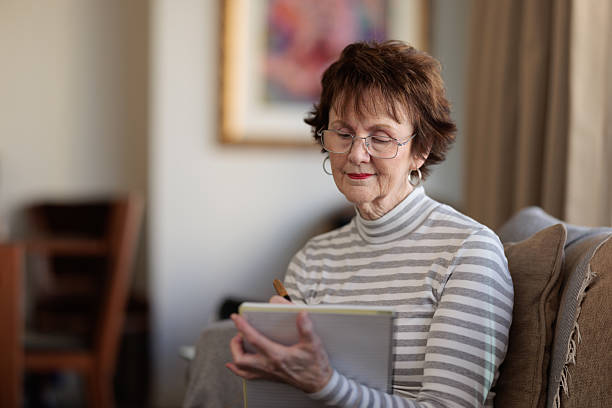 istock Senior woman writing in a notepad 2219263196