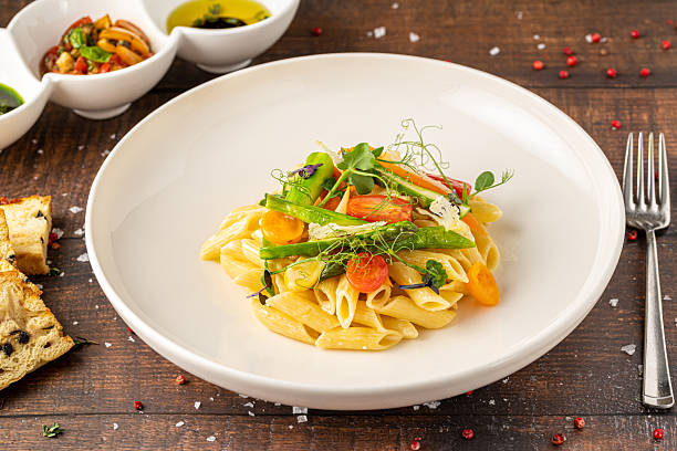 istock Creamy penne pasta with asparagus, cherry tomatoes and microgreens 2219264202