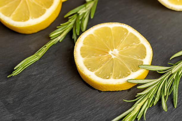 ripe yellow lemon on a black slate board, freshly sliced lemon on a black board close up