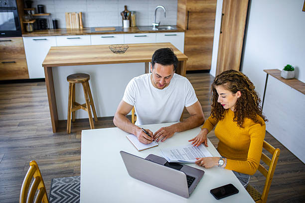 istock Young couple using laptop while planning their home budget 2219267050