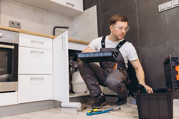 istock Plumber fixing pipes and checking inside toolbox in kitchen sink cabinet 2219267066