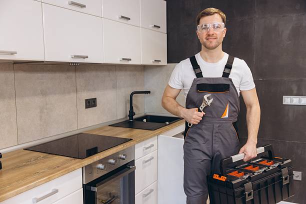 istock Plumber holding wrench and toolbox, smiling in kitchen 2219267073