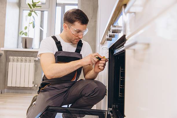 istock Professional handyman repairing oven in kitchen using screwdriver 2219267121