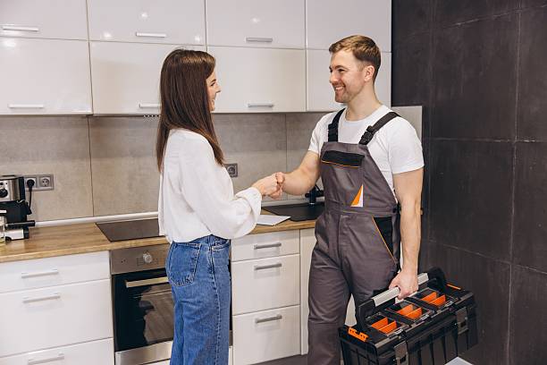 istock Plumber shaking hands with woman after finishing work in kitchen 2219267245