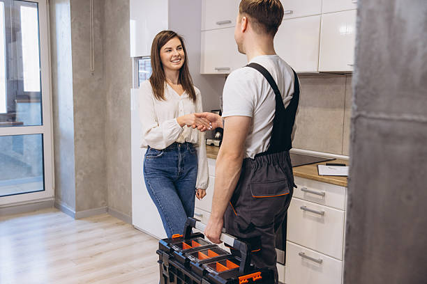 istock Plumber shaking hands with woman after finishing work in kitchen 2219267258