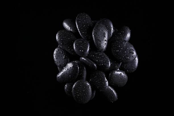 close up on stack of black pebbles  on rocky beach
