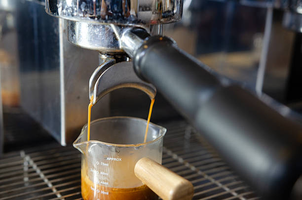 istock Coffee flowing from Portafilters being brewed in an espresso machine. 2219272527