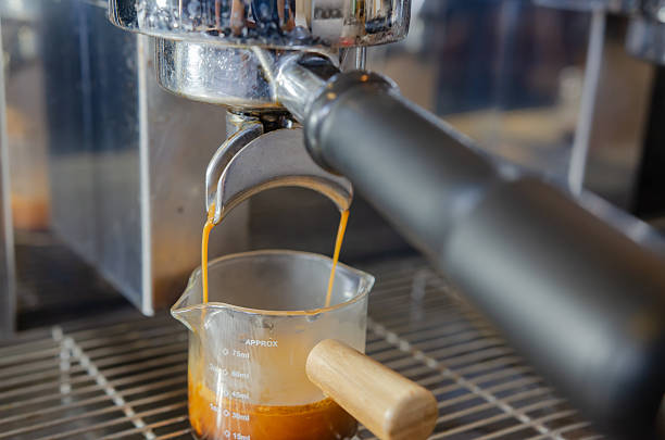 istock Coffee flowing from Portafilters being brewed in an espresso machine. 2219272546