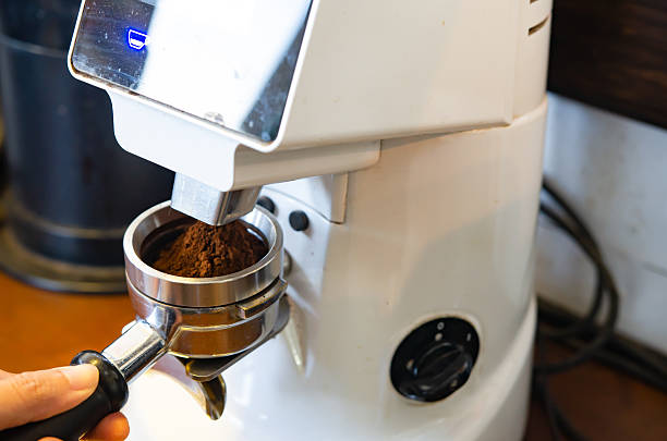 istock Hand holds a metal filter holder with grinded coffee beans in a coffee machine close-up, making espresso coffee 2219272796