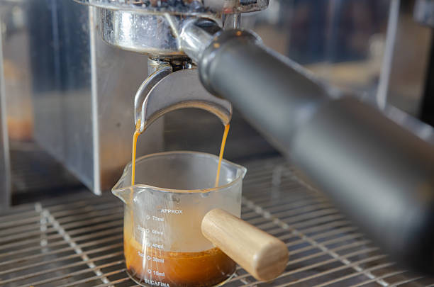 istock Coffee flowing from Portafilters being brewed in an espresso machine. 2219272950