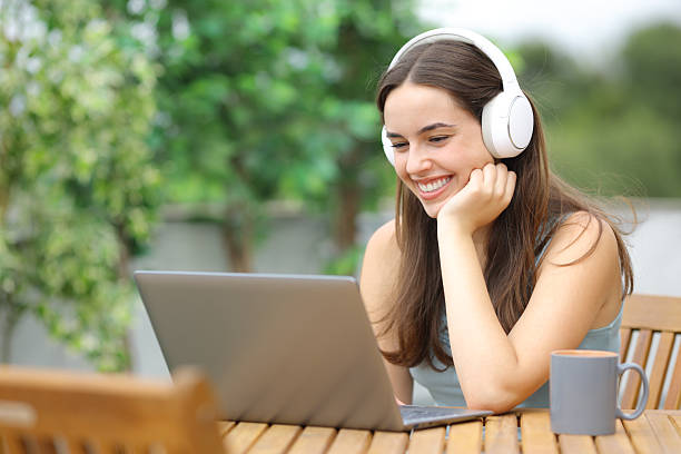 istock Happy woman watching media using computer and headphone 2219273015