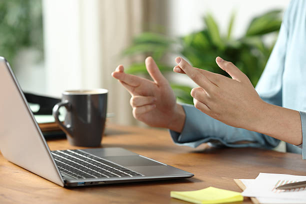 istock Office worker crossing fingers checking laptop on wooden table 2219273381