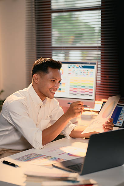 Smiling graphic designer presenting colorful design charts during an online meeting