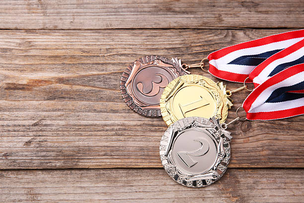 Golden, silver and bronze medals on wooden background, space for text