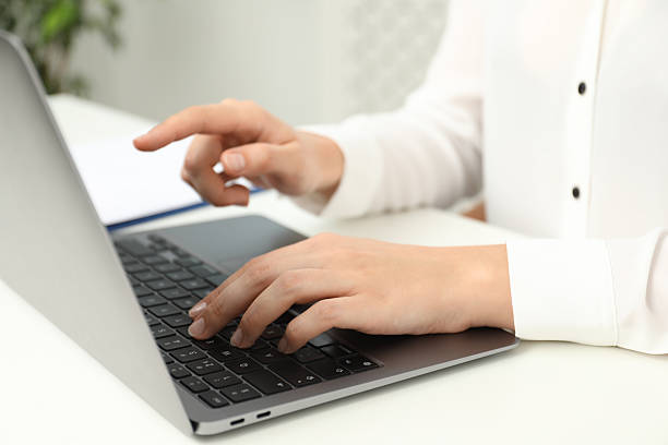 istock Businesswoman using laptop at white table indoors, closeup. Modern technology 2219279980