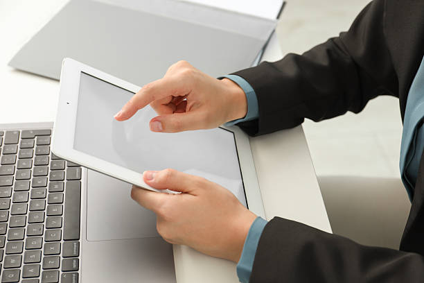 istock Businesswoman using tablet at white table indoors, closeup. Modern technology 2219280052