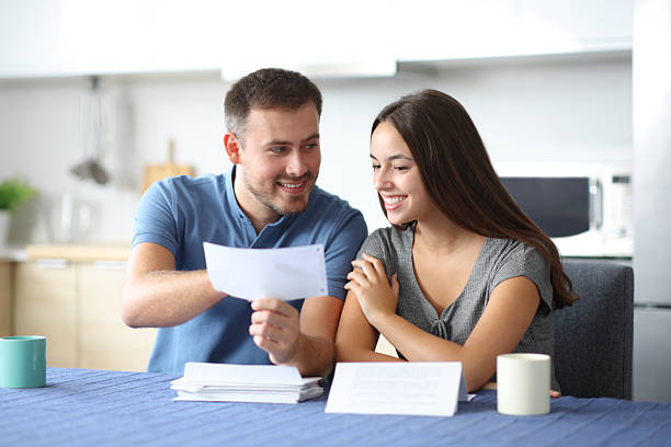 istock Happy couple talking about bank statement at home 2219280416