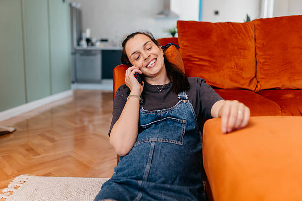 istock Pregnant woman using the phone at home 2219281884