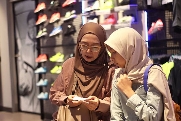 istock Two women are checking the purchasing order at a shoe store. 2219285385