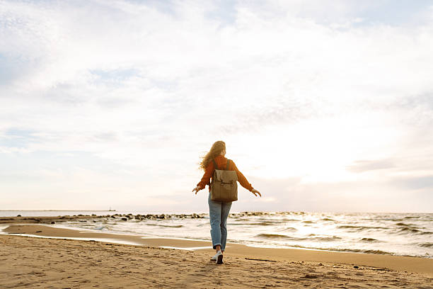 istock Traveler with backpack standing on sunset beach, feeling freedom. 2219285414