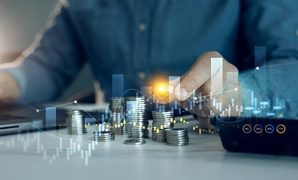 istock Businessman hand putting money coin stack with growing business graph. Saving money concept. Financial growth data or investment market profit bar and success report. 2219286558