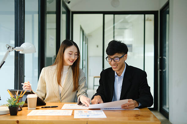 istock Two business people discuss financial strategy and collaborate with colleagues. 2219287297