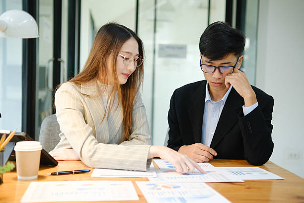 istock Two business people discuss financial strategy and collaborate with colleagues. 2219287306