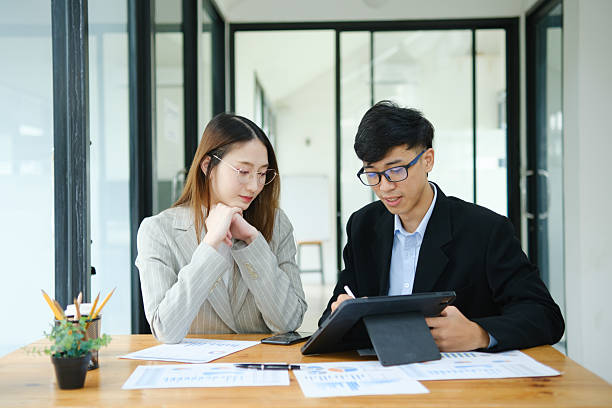 istock Two business people discuss financial strategy and collaborate with colleagues. 2219287320
