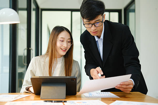 istock Two business people discuss financial strategy and collaborate with colleagues. 2219287395
