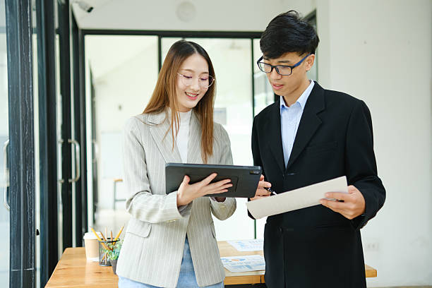 istock Two business people discuss financial strategy and collaborate with colleagues. 2219287403