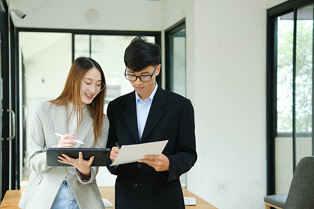 istock Two business people discuss financial strategy and collaborate with colleagues. 2219287432