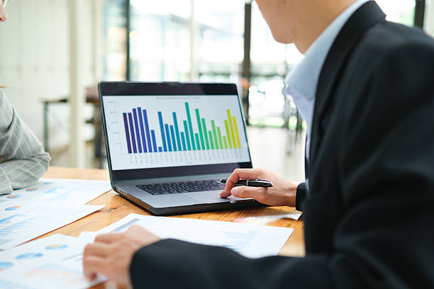 istock Two business people discuss financial strategy and collaborate with colleagues. 2219287466
