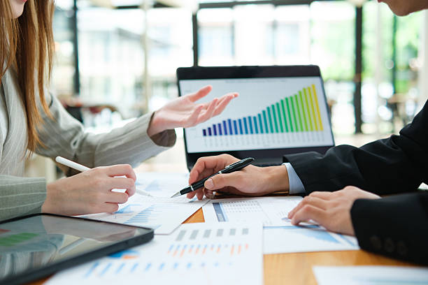 istock Two business people discuss financial strategy and collaborate with colleagues. 2219287486