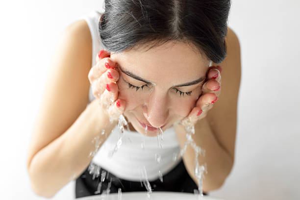 istock Female washing her face 2219290292