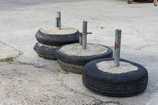 istock Three Rusty Metal Poles Embedded in Concrete Bases Made From Recycled Tires Outdoor Setting 2219290846