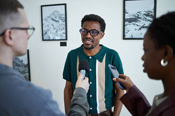 istock Interviewing Man in Green Shirt During Art Exhibition 2219291770