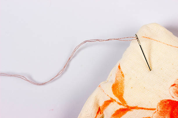istock a sewing needle with a threaded thread is stuck into a soft pad for it. sewing needles of various sizes in a black organizer.taken in close-up with a place for text, an object, a product, or an advertisement, on a white background. 2219293269