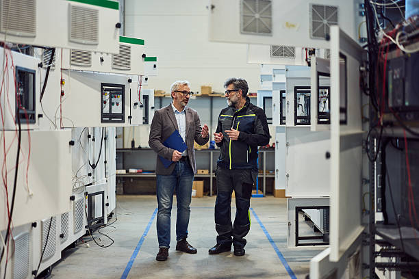 Engineers Discuss Industry Technology in Factory Setting Among Advanced Equipment stock photo