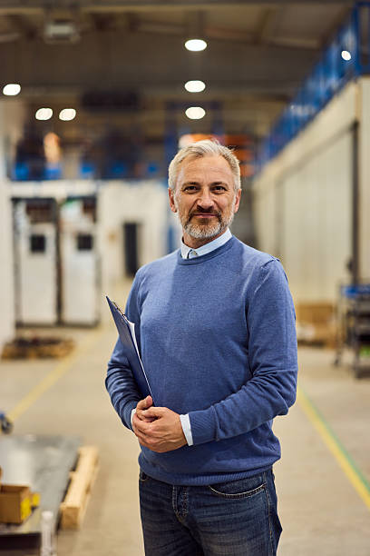 istock Confident Business Professional Posing in Industrial Workspace With Clipboard 2219297153