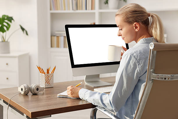 istock Woman working at table with computer monitor in office. Mockup for design 2219298232